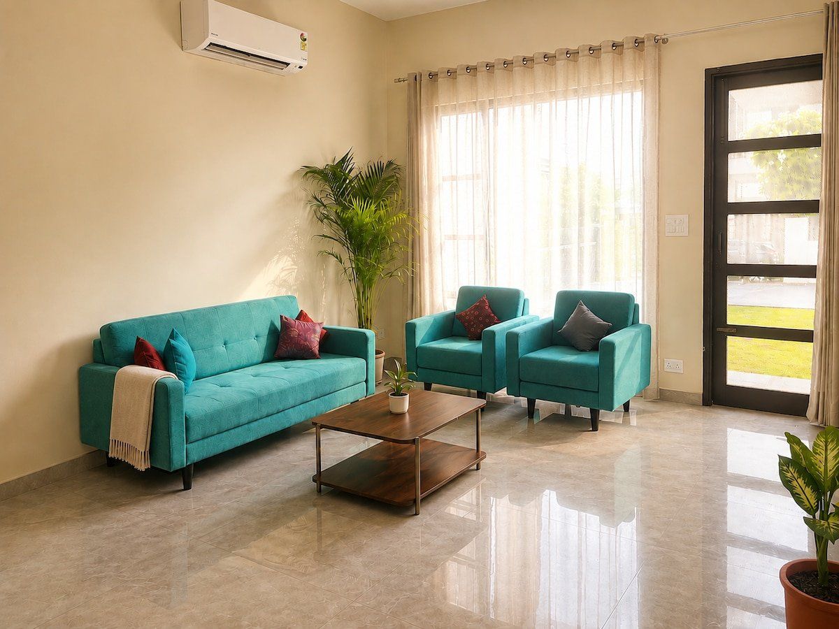 Bright living room with a teal sofa, armchairs and a glass door to the garden